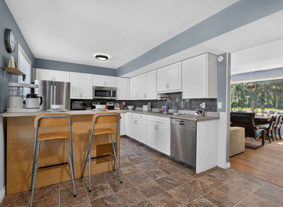 Discover this charming kitchen featuring crisp white cabinetry and a sleek stainless steel dishwasher.
