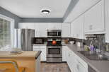 This spacious kitchen features sleek stainless steel appliances, including a refrigerator, microwave, and oven.