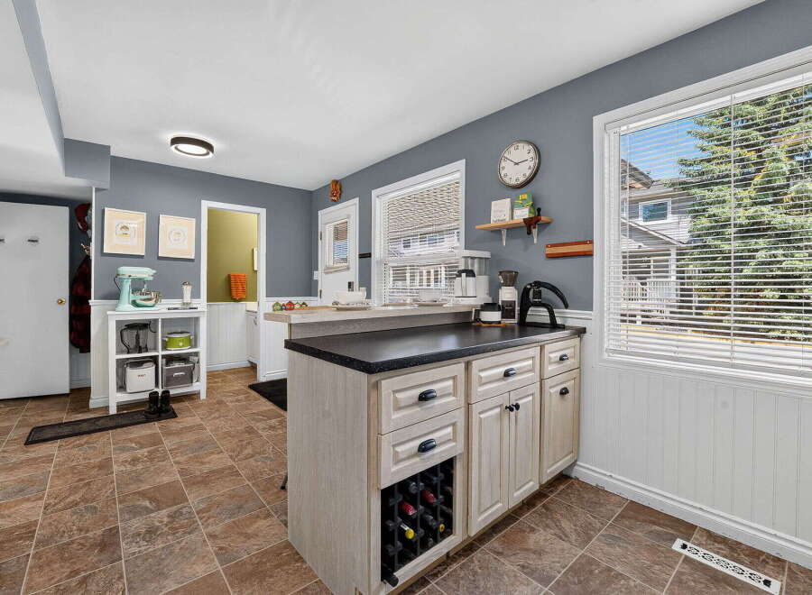 This spacious kitchen features a large island with a wine rack and ample counter space, perfect for meal preparation and entertaining.