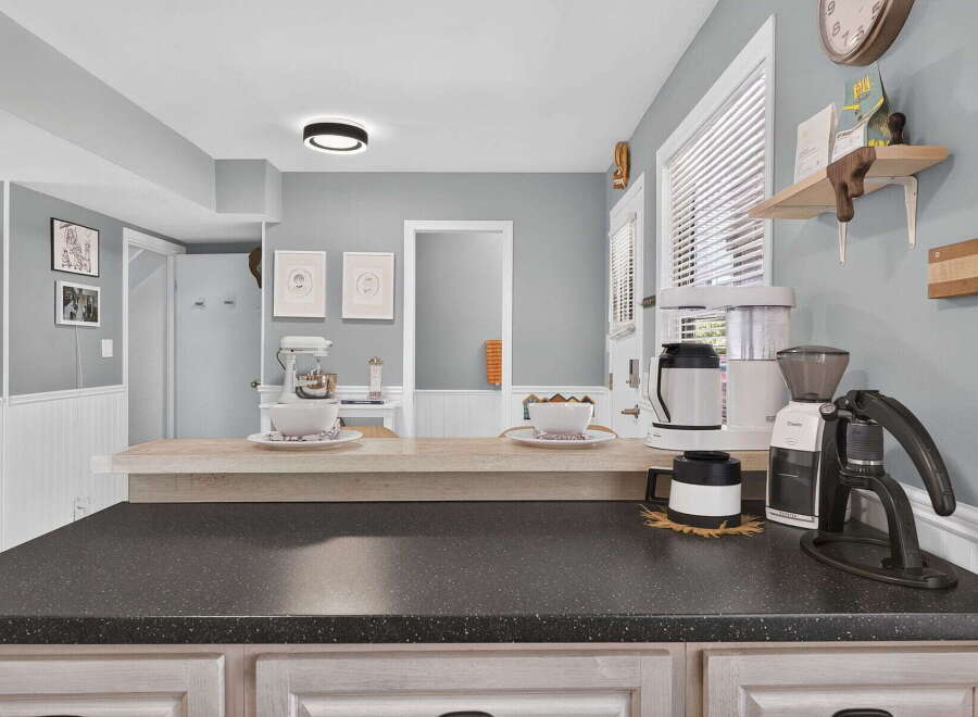 Enjoy your morning coffee in this beautifully appointed kitchen, featuring a sleek coffee station with a grinder and brewer.