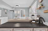 Enjoy your morning coffee in this beautifully appointed kitchen, featuring a sleek coffee station with a grinder and brewer.