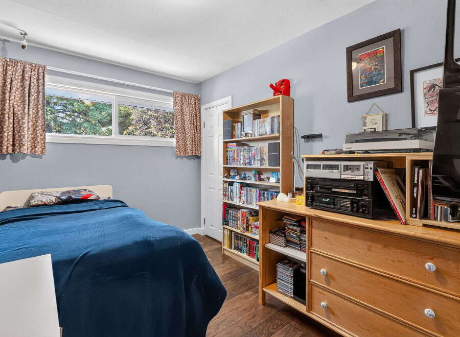 Discover this cozy bedroom featuring a comfortable bed with a deep blue comforter, perfect for relaxation.