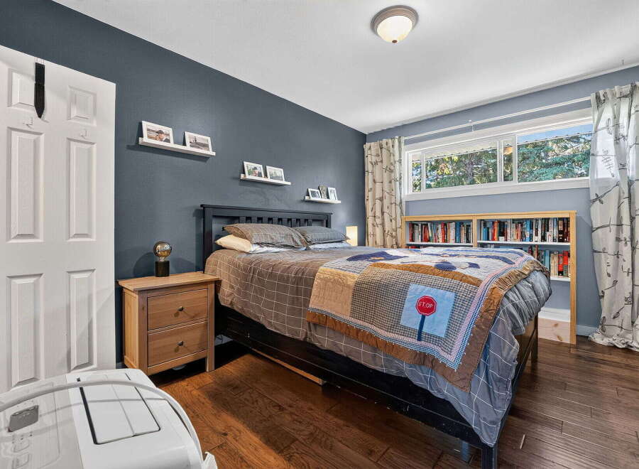 Discover this inviting bedroom featuring a comfortable queen-size bed adorned with a unique stop sign quilt, perfect for a restful night's sleep.