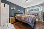 Discover this inviting bedroom featuring a comfortable queen-size bed adorned with a unique stop sign quilt, perfect for a restful night's sleep.