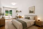 Discover this serene bedroom featuring a comfortable bed with plush linens and a calming green accent throw.