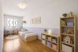 This charming children's bedroom features a cozy twin bed with playful bedding and ample storage drawers.