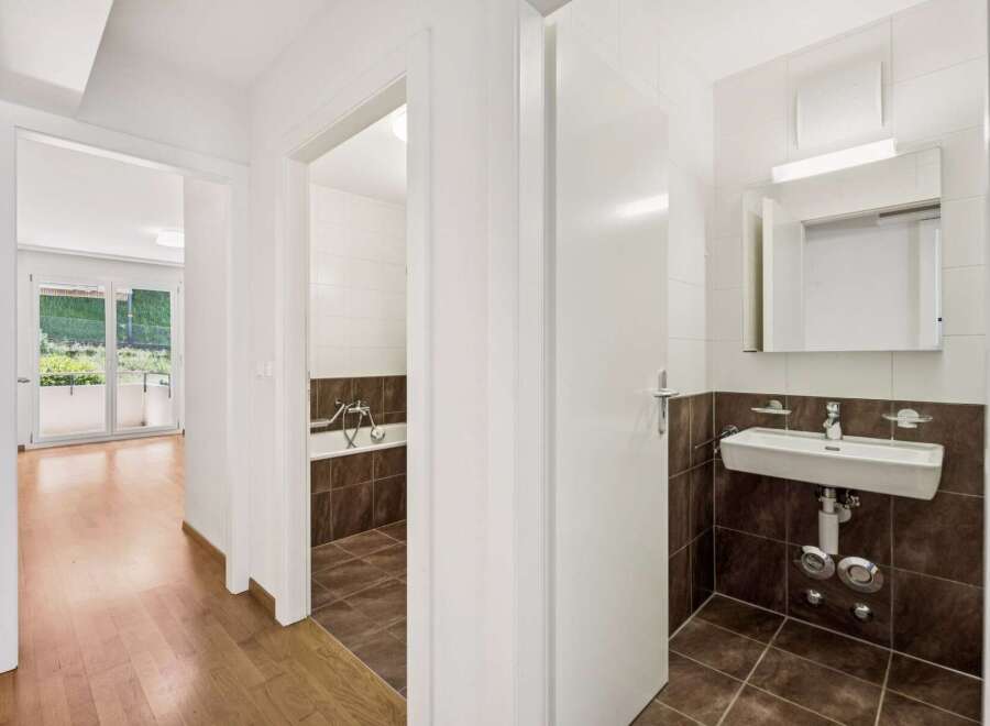 Step into this charming apartment featuring a well-appointed bathroom with a bathtub and a separate sink area.