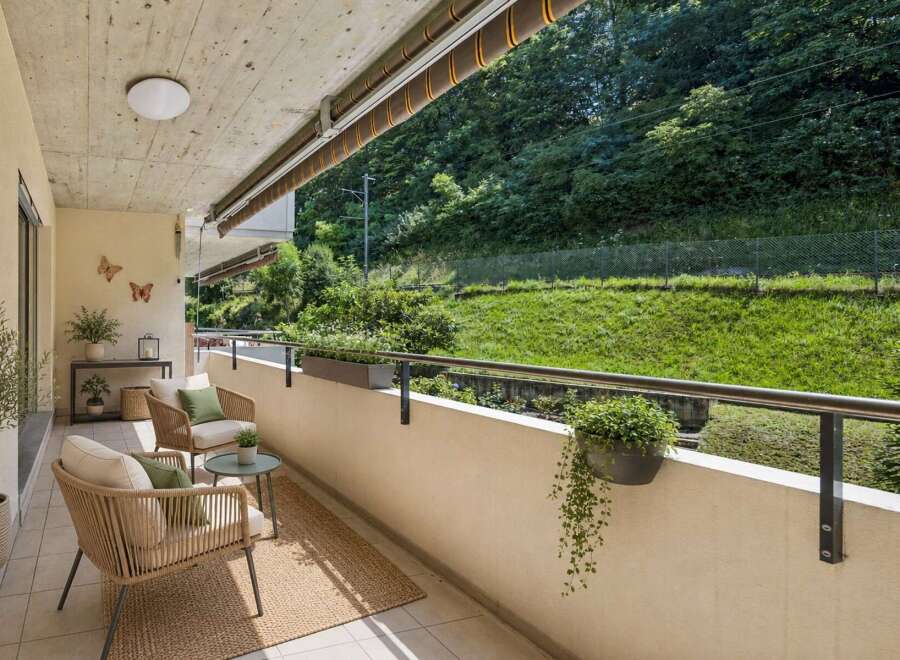Enjoy your morning coffee on this charming balcony, complete with comfortable seating and lush greenery.