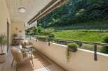 Enjoy your morning coffee on this charming balcony, complete with comfortable seating and lush greenery.