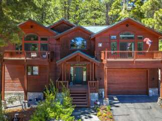 Nestled amidst towering pine trees, this stunning wooden mountain home offers a serene retreat.