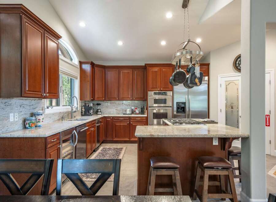 This spacious kitchen boasts rich cherry wood cabinetry, granite countertops, and a large island perfect for entertaining.