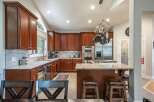 This spacious kitchen boasts rich cherry wood cabinetry, granite countertops, and a large island perfect for entertaining.