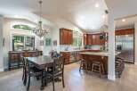 This spacious kitchen and dining area boasts rich cherry wood cabinetry, granite countertops, and a large island perfect for entertaining.