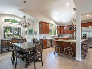This spacious kitchen and dining area boasts rich cherry wood cabinetry, granite countertops, and a large island perfect for entertaining.