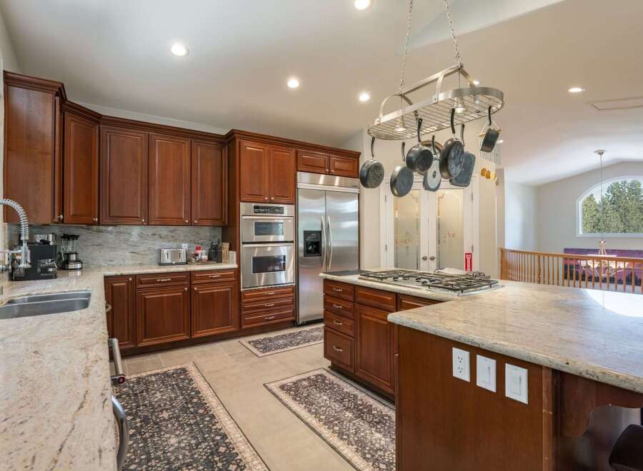 This spacious kitchen boasts rich cherry wood cabinetry and elegant granite countertops, perfect for any home chef.