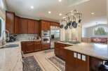 This spacious kitchen boasts rich cherry wood cabinetry and elegant granite countertops, perfect for any home chef.