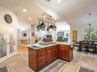 This spacious open-concept kitchen features a large island with a gas stovetop, perfect for culinary enthusiasts.