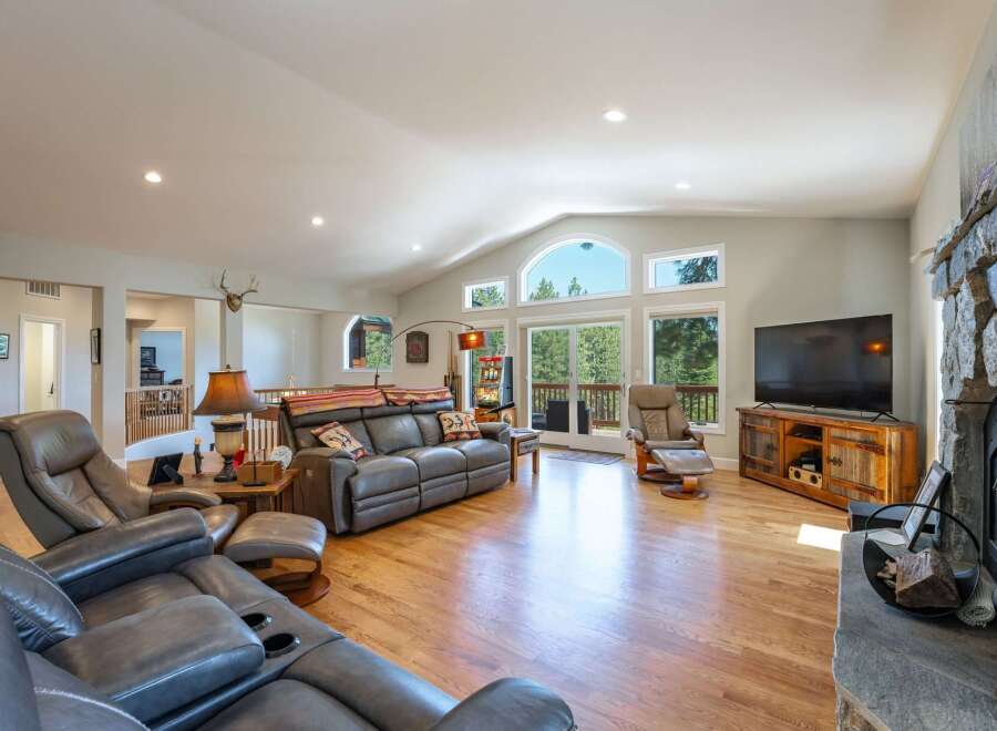 Experience luxurious living in this spacious great room, featuring vaulted ceilings and a wall of windows that flood the space with natural light.