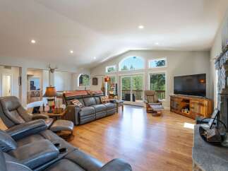 Experience luxurious living in this spacious great room, featuring vaulted ceilings and a wall of windows that flood the space with natural light.