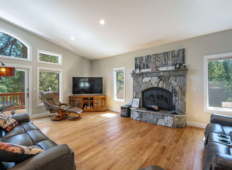 Experience cozy living in this spacious great room, featuring a stunning floor-to-ceiling stone fireplace as the centerpiece.