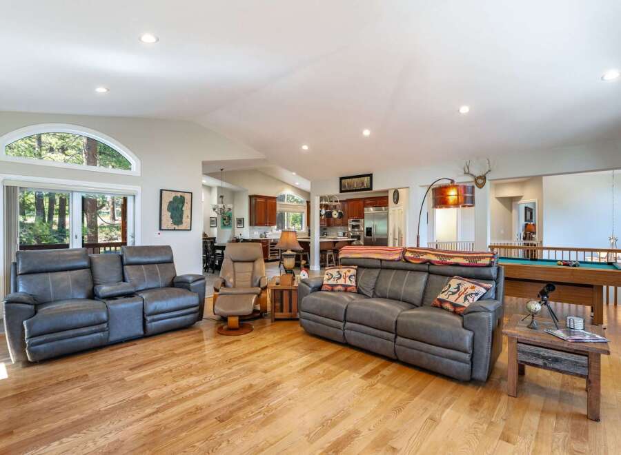 Experience spacious open-concept living with this inviting great room, featuring comfortable leather seating and a cozy fireplace.
