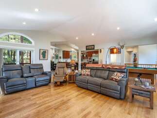 Experience spacious open-concept living with this inviting great room, featuring comfortable leather seating and a cozy fireplace.