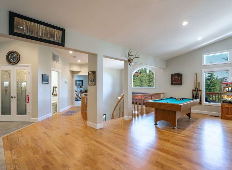 Experience ultimate entertainment in this spacious game room featuring a professional pool table and a vintage arcade game.