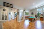 Experience ultimate entertainment in this spacious game room featuring a professional pool table and a vintage arcade game.