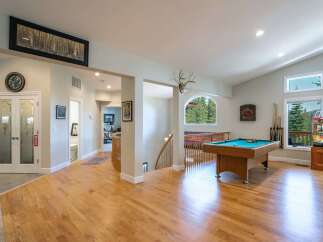 Experience ultimate entertainment in this spacious game room featuring a professional pool table and a vintage arcade game.