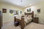 Experience rustic charm in this inviting bedroom, featuring a cozy queen-size bed with a woodland-themed comforter and matching pillows.