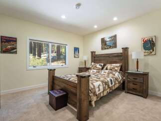 Experience rustic charm in this inviting bedroom, featuring a cozy queen-size bed with a woodland-themed comforter and matching pillows.