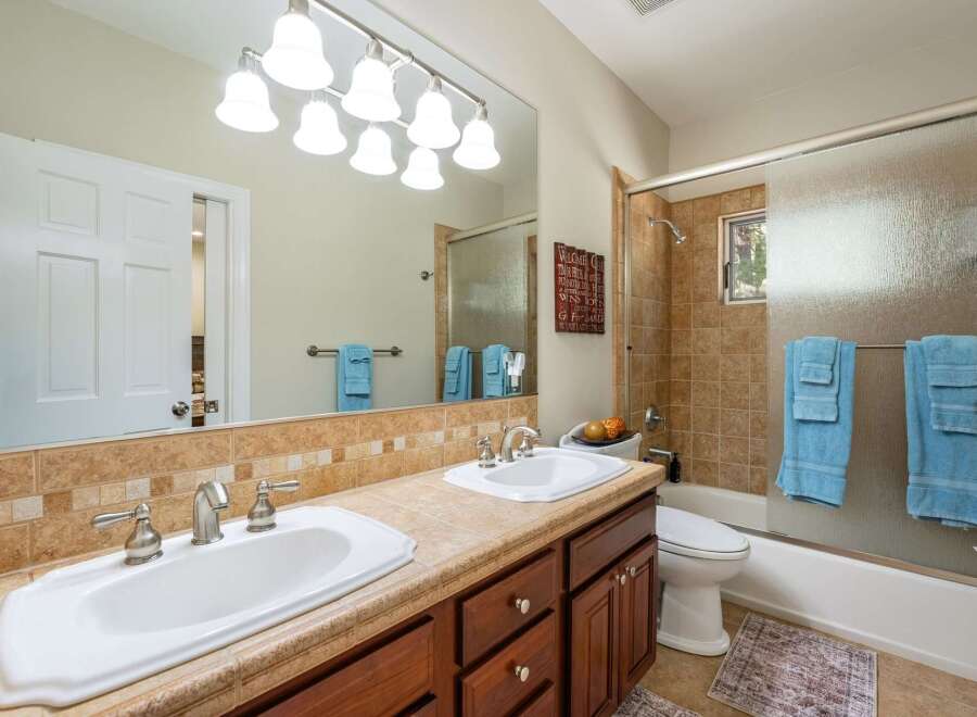 This spacious bathroom features a double vanity with ample counter space and two sinks, perfect for busy mornings.
