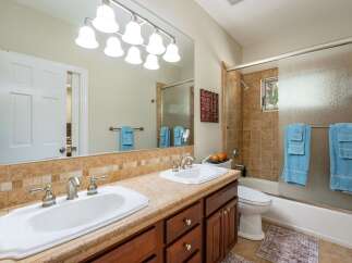 This spacious bathroom features a double vanity with ample counter space and two sinks, perfect for busy mornings.