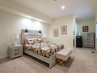 Experience rustic charm in this inviting bedroom, featuring a queen-sized bed with a unique wood-plank headboard and cozy bear-themed bedding.