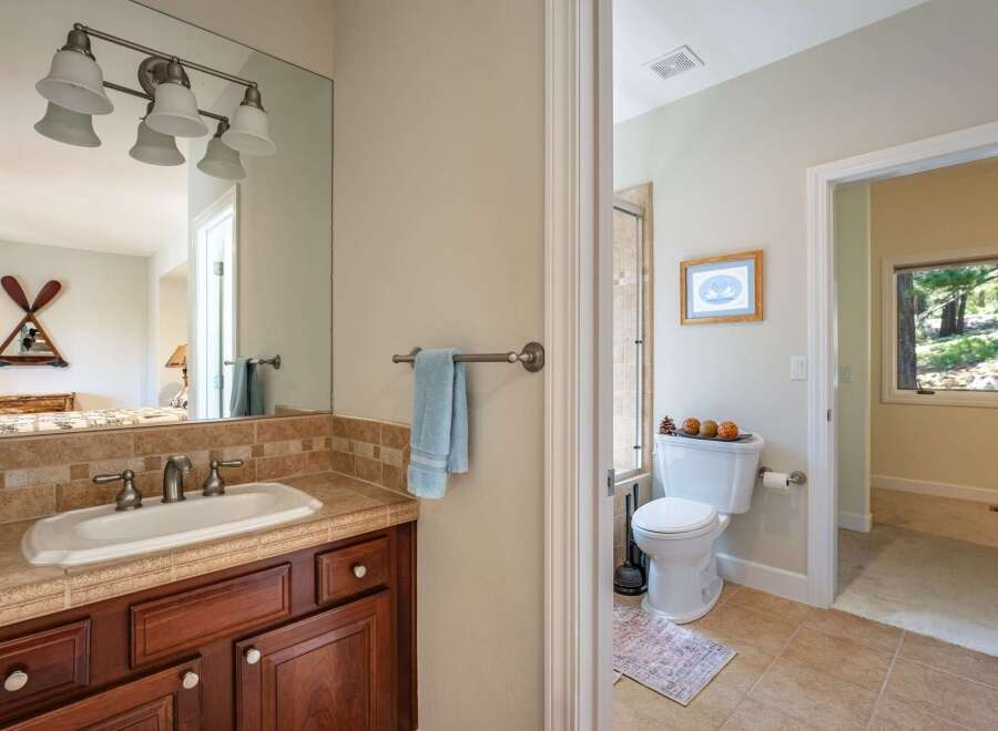 This charming bathroom features a spacious vanity with a tiled backsplash and a large mirror, perfect for your morning routine.