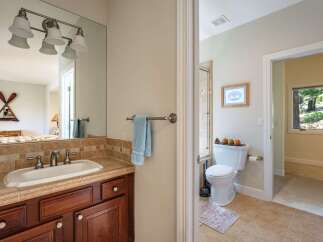 This charming bathroom features a spacious vanity with a tiled backsplash and a large mirror, perfect for your morning routine.