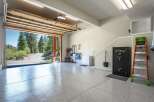 Discover this spacious garage featuring a pristine epoxy-coated floor, perfect for protecting your vehicles.