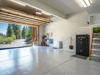 Discover this spacious garage featuring a pristine epoxy-coated floor, perfect for protecting your vehicles.