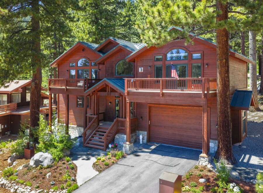 Nestled amongst tall pine trees, this stunning multi-level wooden home offers a picturesque retreat.