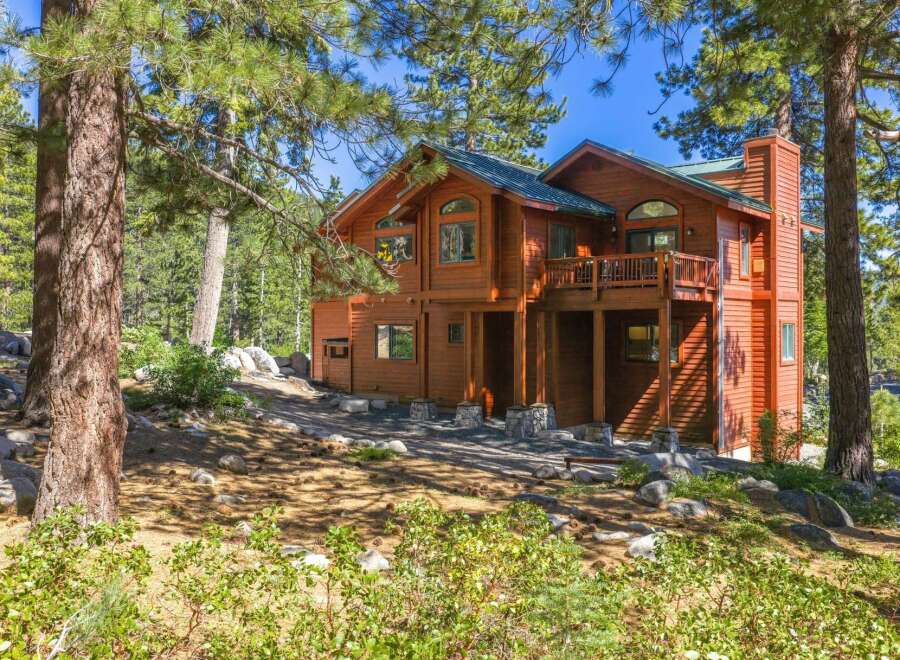 Nestled among tall pine trees, this stunning wooden home offers a serene mountain retreat.