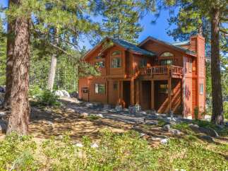 Nestled among tall pine trees, this stunning wooden home offers a serene mountain retreat.