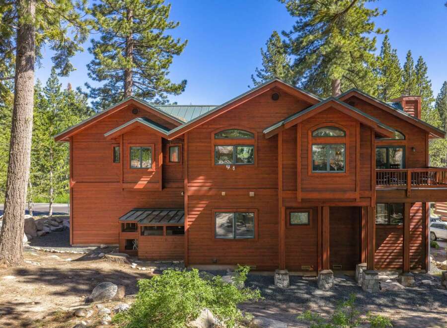 Nestled amidst tall pine trees, this stunning wooden home offers a serene mountain retreat.