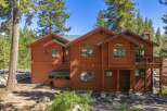 Nestled amidst tall pine trees, this stunning wooden home offers a serene mountain retreat.