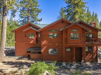 Nestled amidst tall pine trees, this stunning wooden home offers a serene mountain retreat.