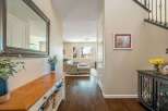 Step into this inviting entryway featuring a spacious hallway with a large decorative mirror and a charming wooden console table with ample storage.