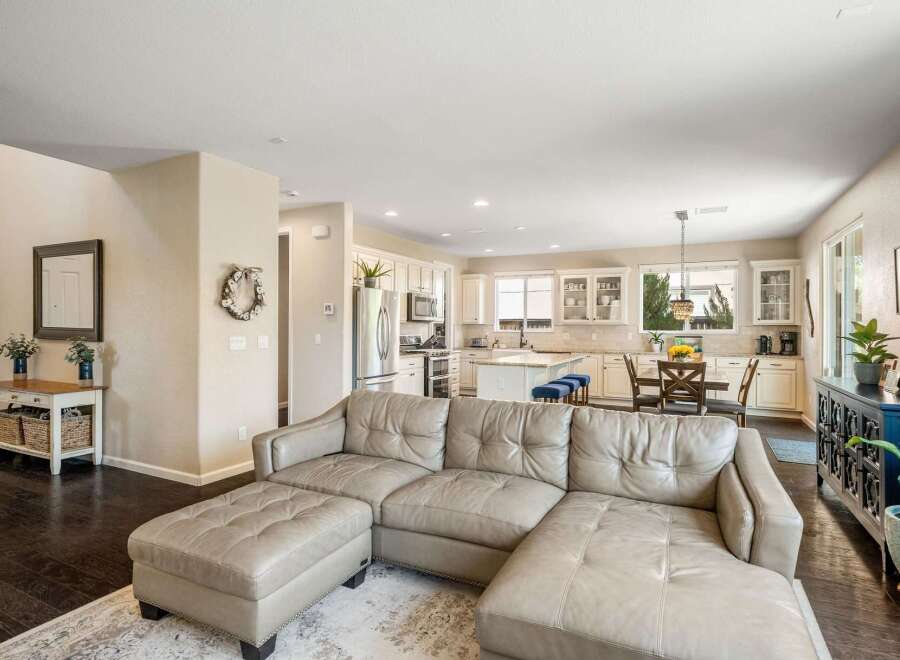 Experience open-concept living in this beautifully appointed home, featuring a spacious living area flowing seamlessly into a modern kitchen and dining space.
