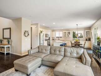 Experience open-concept living in this beautifully appointed home, featuring a spacious living area flowing seamlessly into a modern kitchen and dining space.