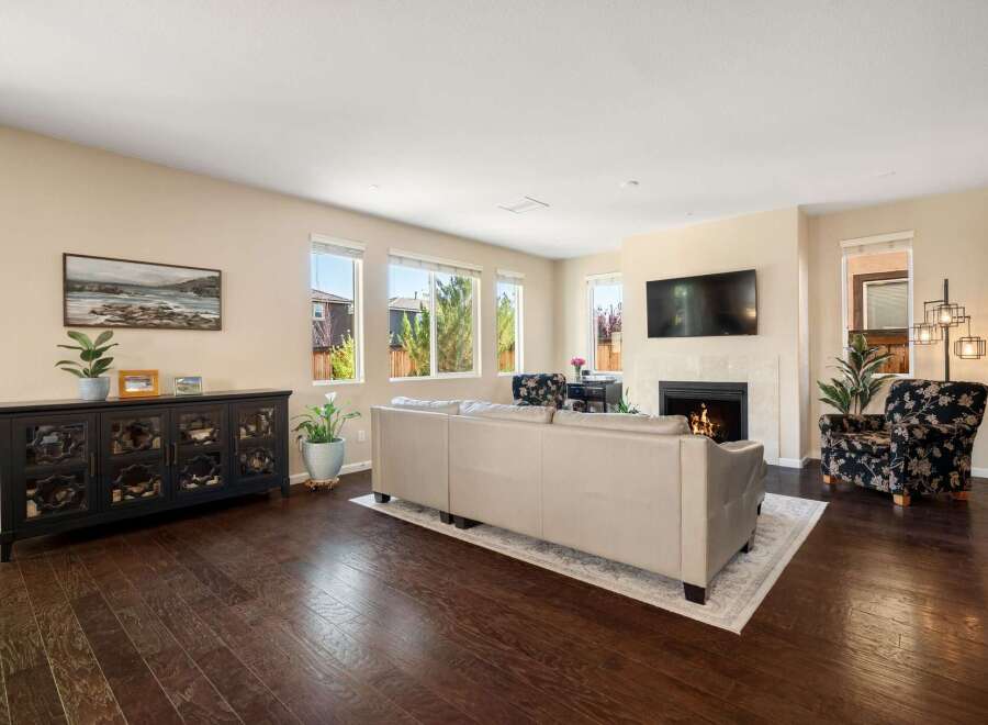 Step into this inviting living room, featuring a plush sofa and a cozy fireplace perfect for relaxing evenings.