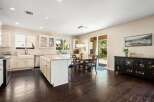 This spacious kitchen boasts a large island with granite countertops, perfect for meal prep and casual dining.