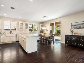 This spacious kitchen boasts a large island with granite countertops, perfect for meal prep and casual dining.